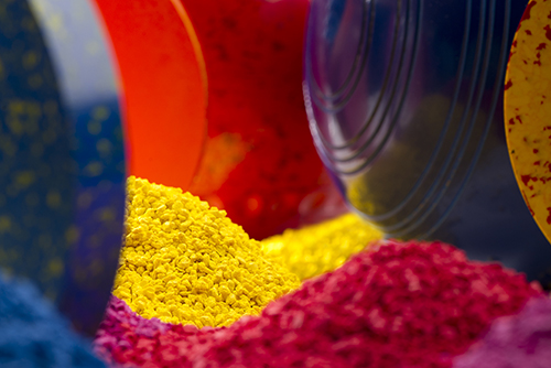 Colourful lawn bowls with the moulding compounds  used to produce them in the foreground